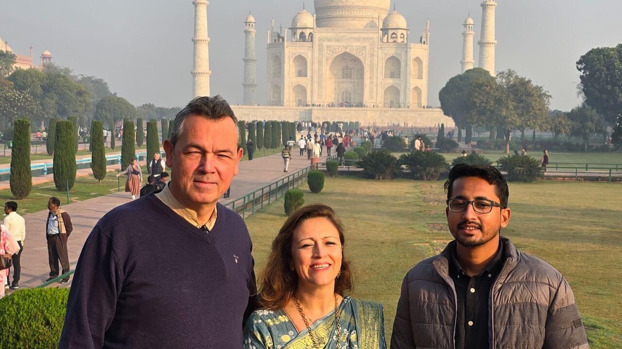 Tourists with their guide posing at the Taj Mahal during sunrise on the Overnight Agra and Ghost City Tour from Delhi