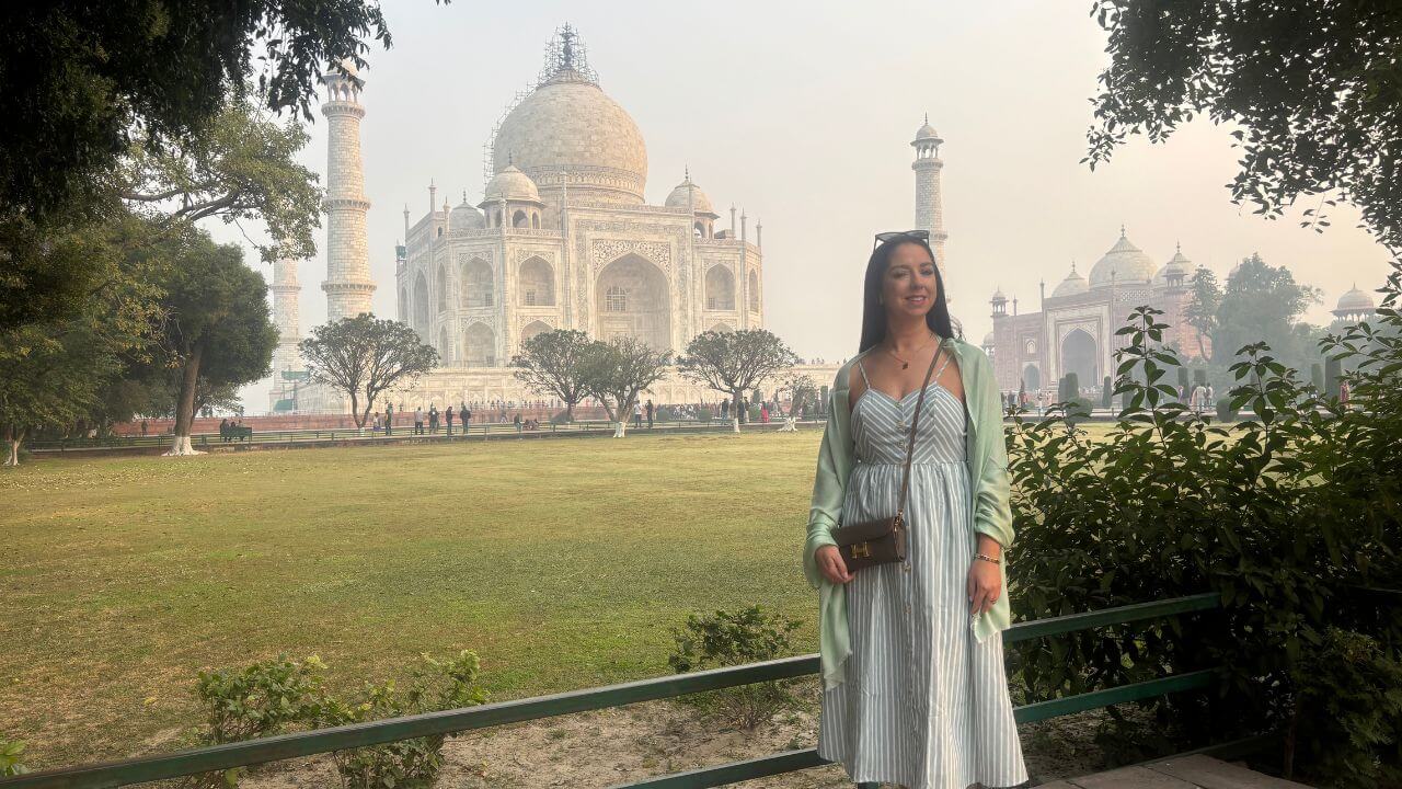 Female traveler posing in front of the Taj Mahal gardens during the Gatimaan Express Same Day Agra Tour