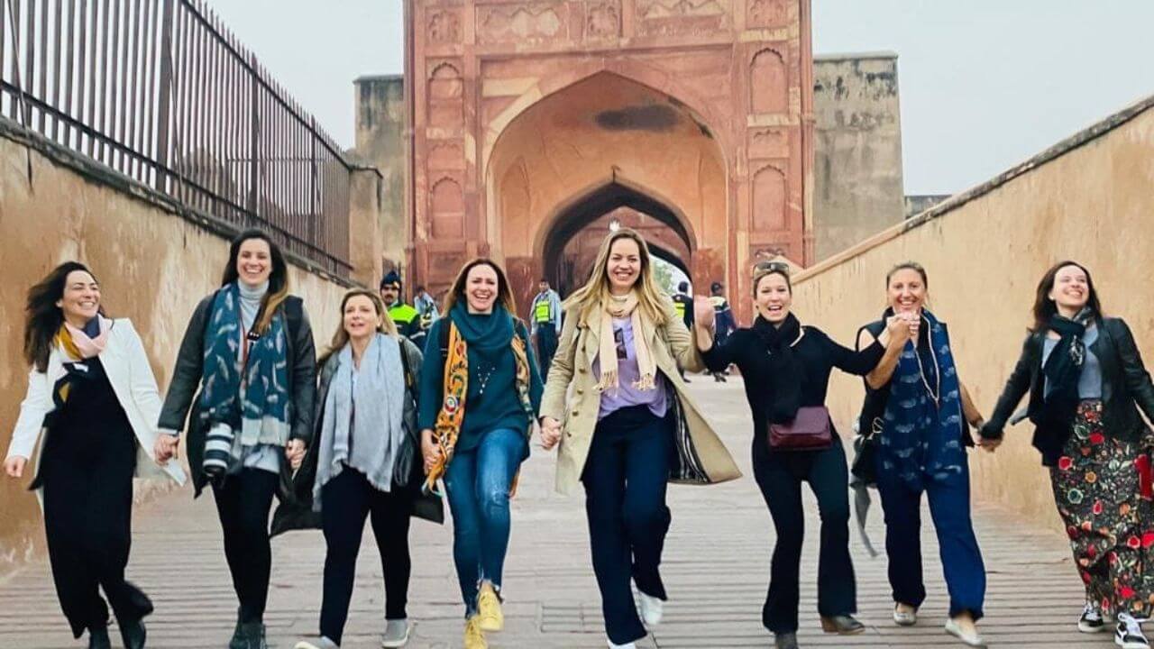 Group of women walking together at the entrance pathway of the Taj Mahal during a Same Day Taj Mahal and Agra Fort Tour from Mumbai.