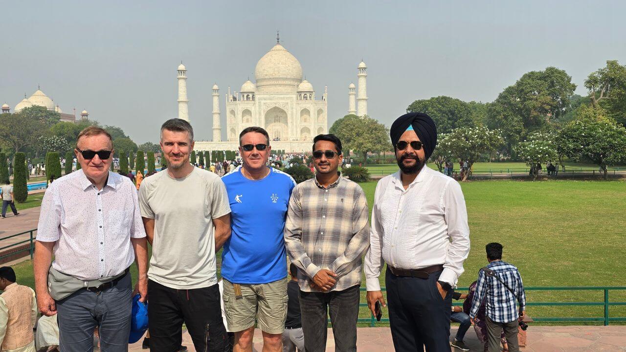 Group of international travelers with their local Indian guide standing in front of the Taj Mahal during a Same Day Taj Mahal Tour from Delhi by car